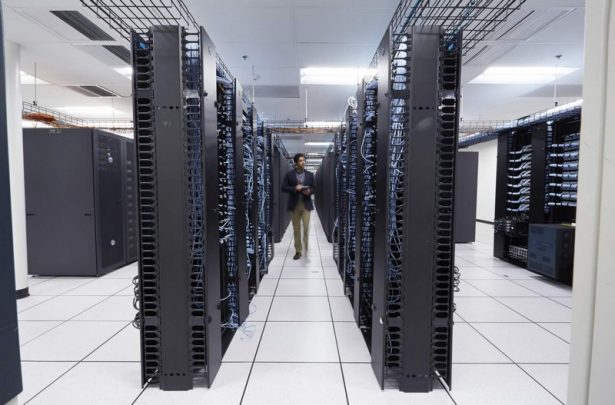 Man Walking in a Large Data Center, Using Venue Tablet