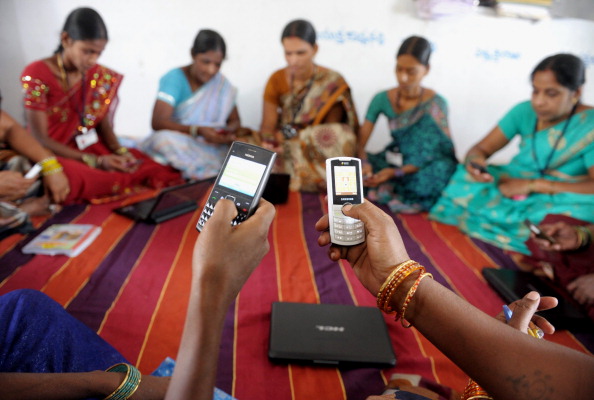 Indian villagers, part of a Self Help Group (SHG) organisation, pose with mobile phones and laptops in Bibinagar village outskirts of Hyderabad on March 7, 2013, on the eve of International Women's day. Members of SHG's make small regular savings contributions over a few months until there is enough capital in the group to begin lending, and they use their mobiles and laptops to record financial transactions. SHG's are seen as instruments for a variety of goals including empowering women, developing leadership abilities among poor people, increasing school enrolments, and improving nutrition and the use of birth control. <a href=