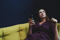 Businesswoman laying in office chillout and holding smartphone